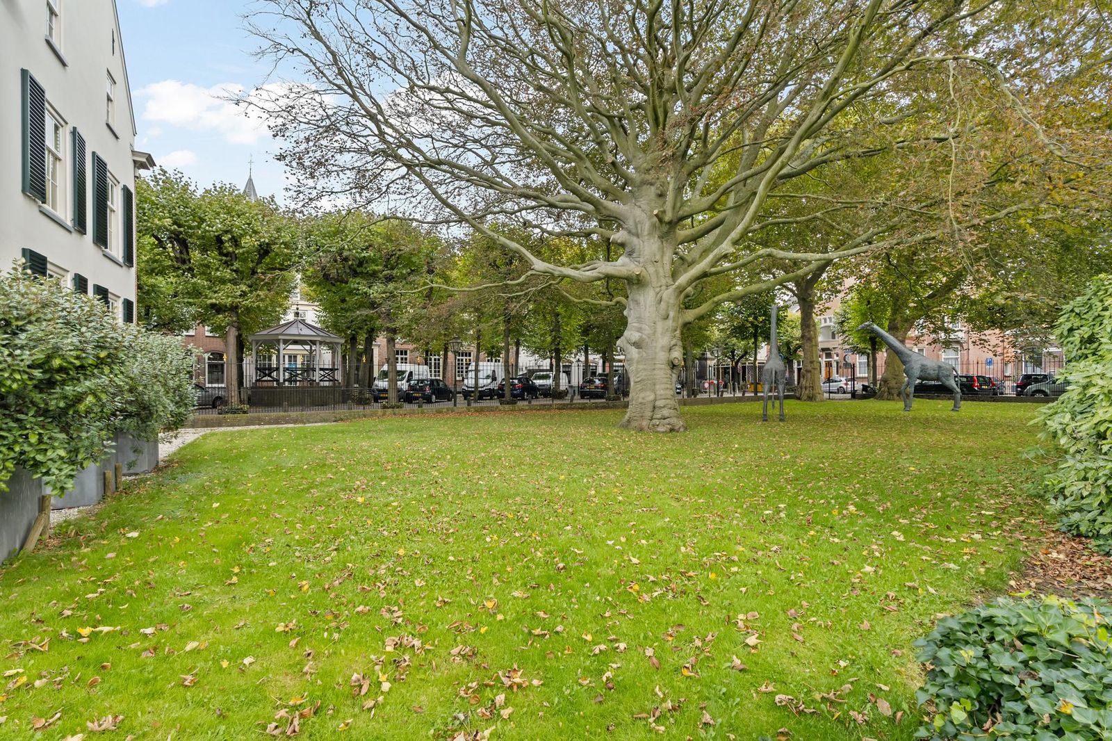Voortuin van Lindenhof in Noordwijk met monumentale boom, gazon en zicht op het Lindenplein