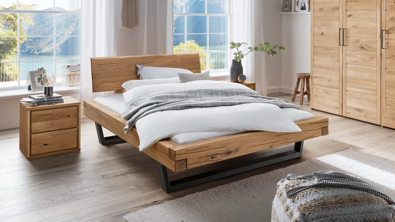 Houten bed in lichte slaapkamer met daglicht en rustige uitstraling