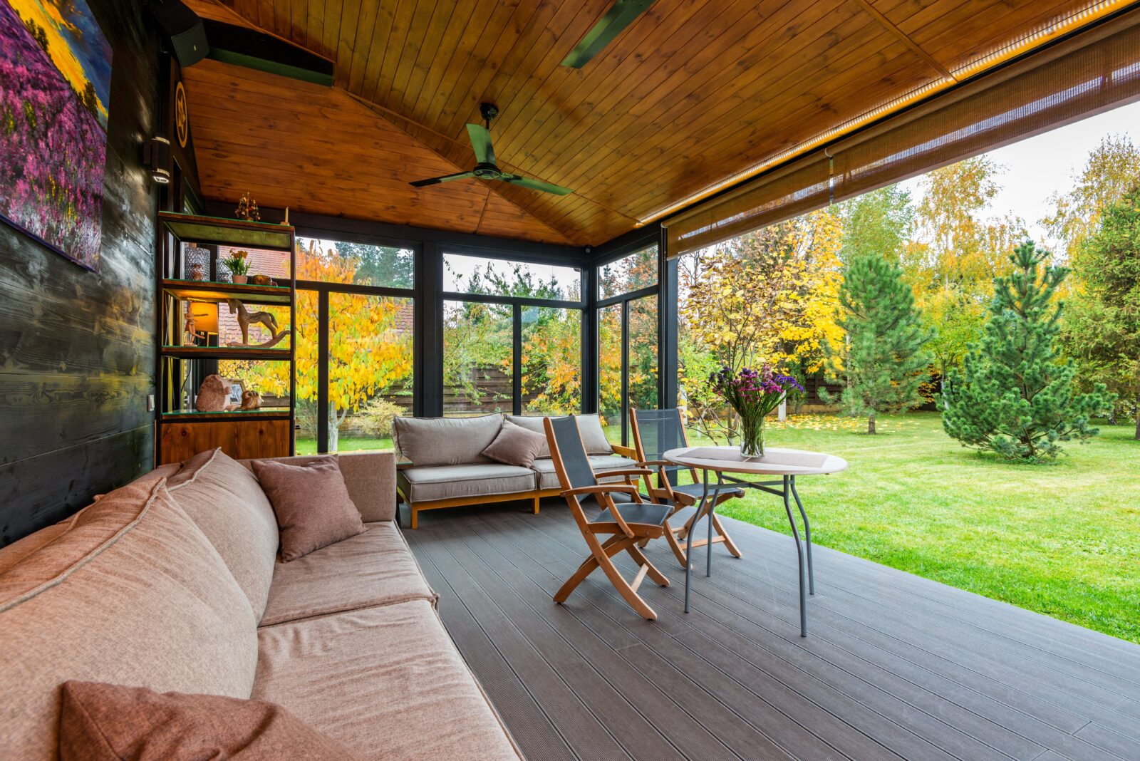 Overdekte veranda met houten plafond en zithoek die extra leefruimte aan de woning toevoegt