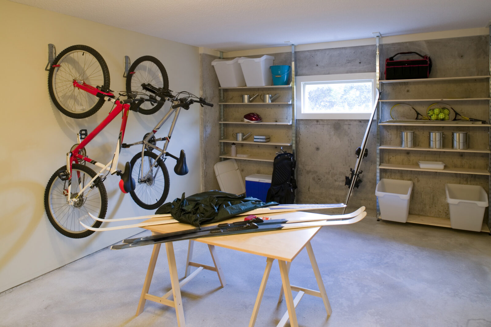Georganiseerde kelder met wandrekken, fietsen en opbergsystemen in een nieuwe woning.