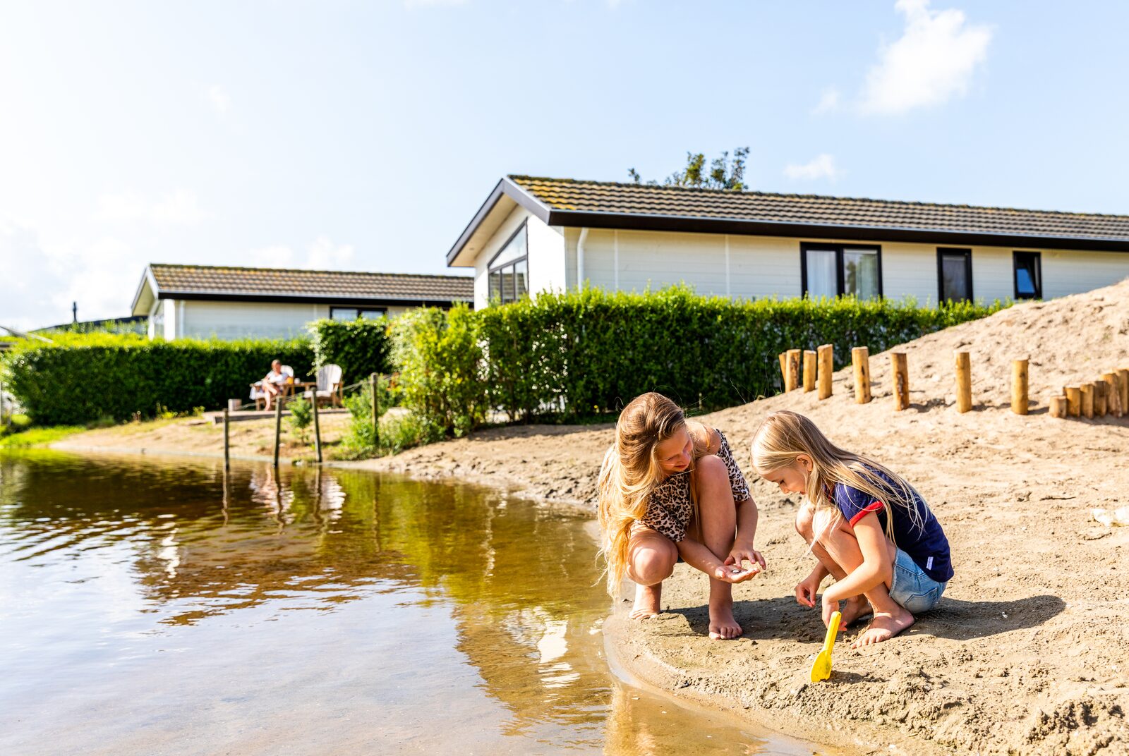Kinderen spelen aan het water bij een vakantiehuis in een rustige omgeving