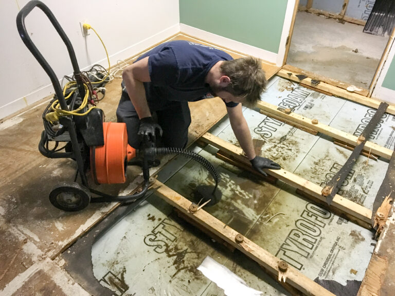 Tijdelijke waterpomp op verrijdbaar frame bij werkzaamheden in een kruipruimte van een woning