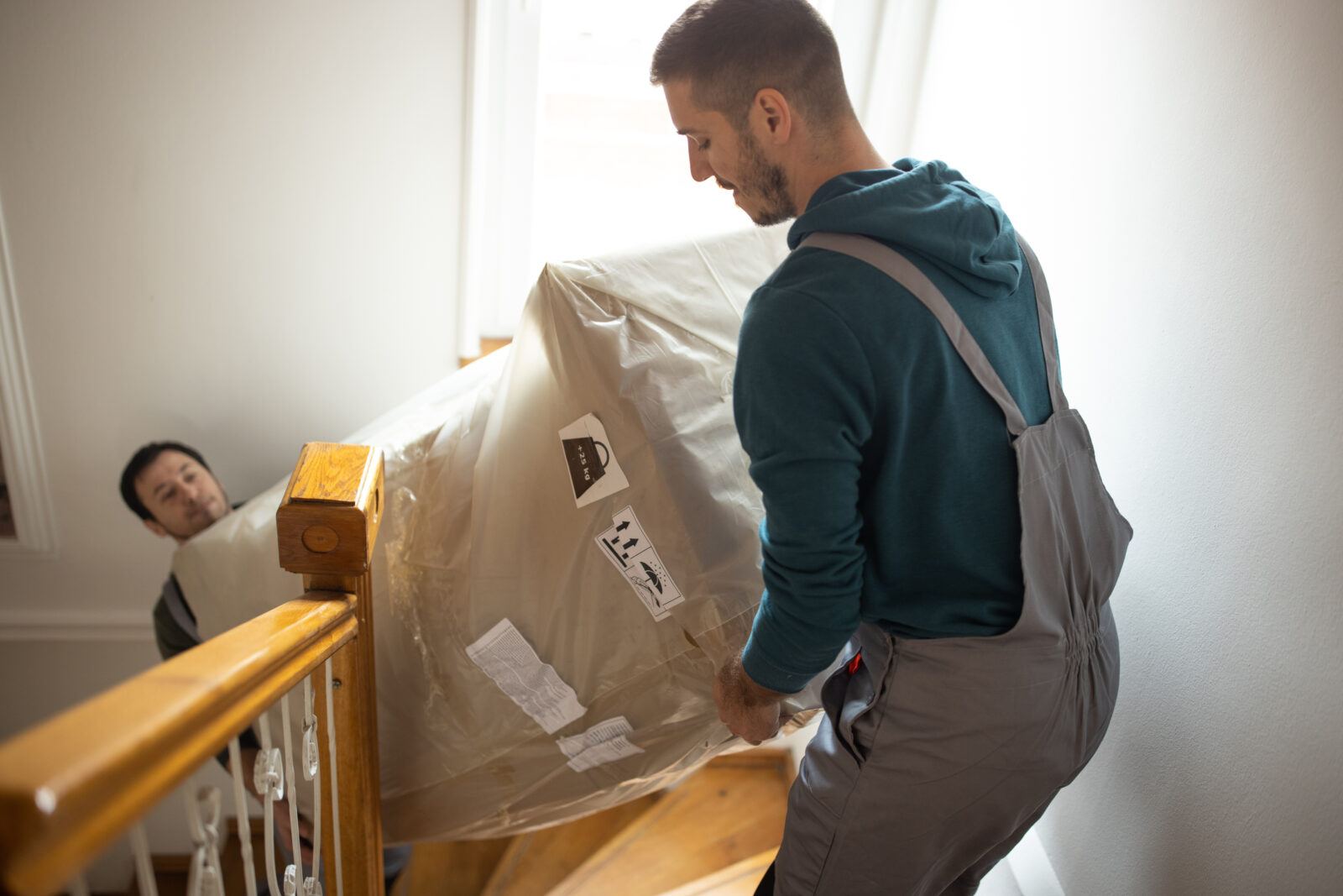 Man verplaatst zwaar object via trap tijdens woningrenovatie
