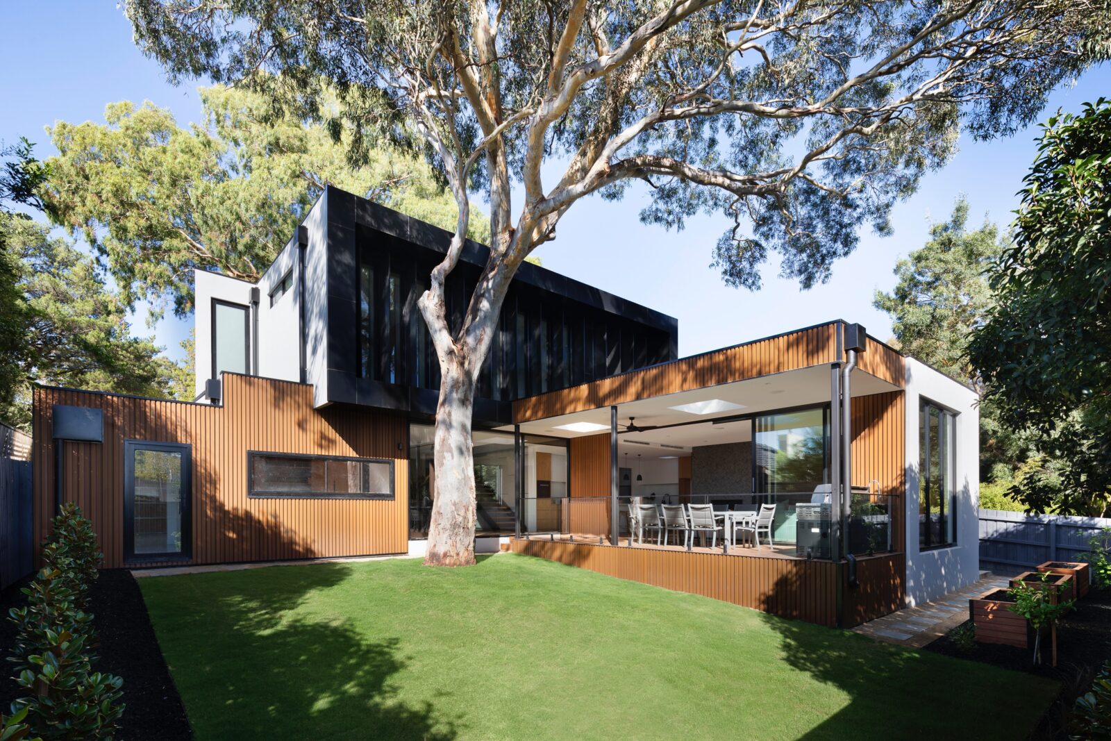 Moderne luxe villa met grote glaspartijen en strakke architectuur in groene tuin