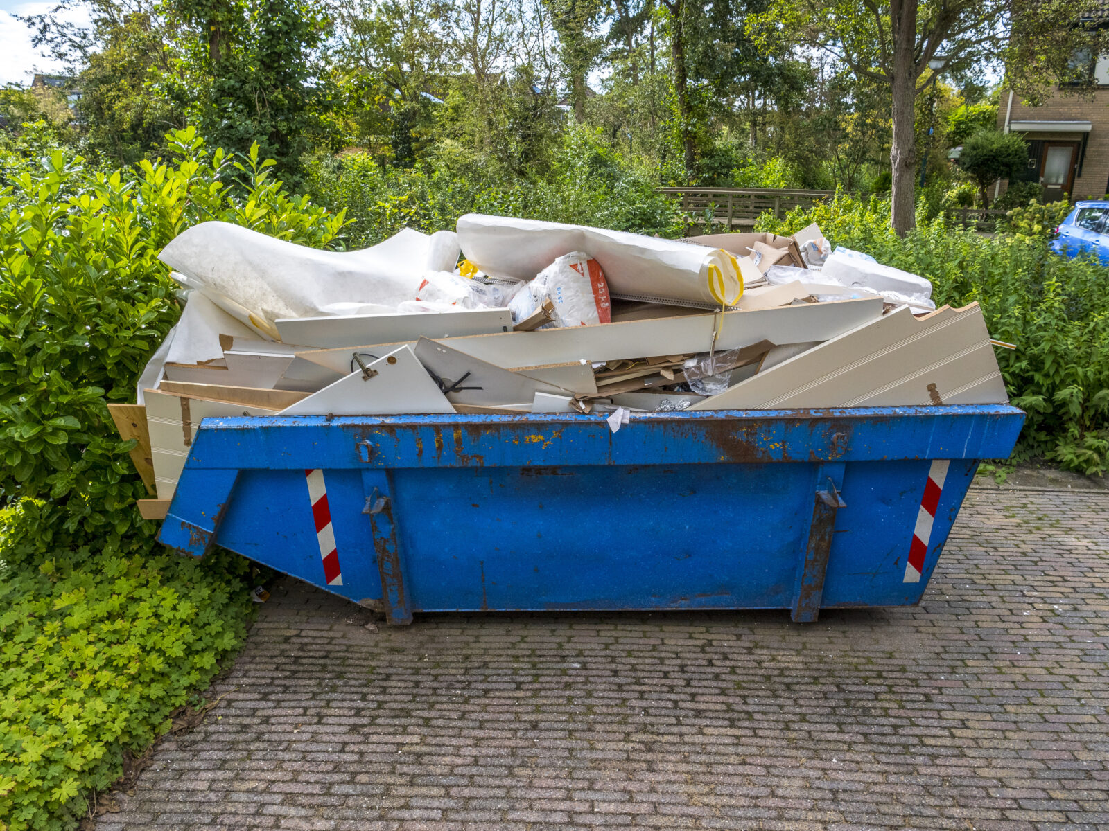 Puincontainer op oprit bij woning tijdens verbouwing