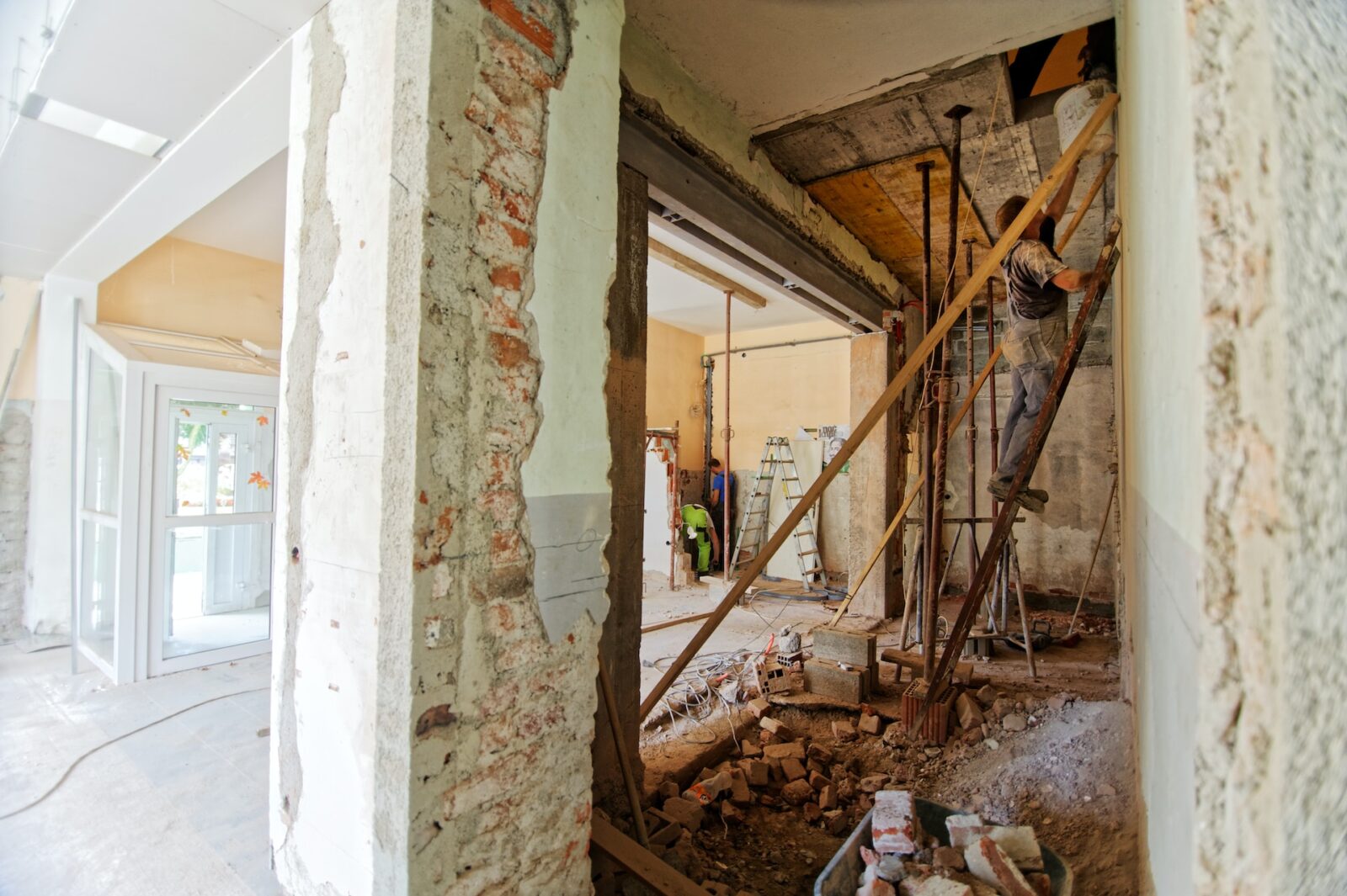 Verbouwing van woning met aannemers aan het werk en opengebroken muren tijdens renovatie