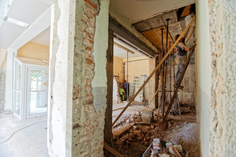 Verbouwing van woning met aannemers aan het werk en opengebroken muren tijdens renovatie