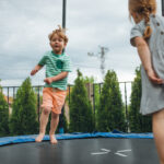 Kinderen springen op trampoline in achtertuin