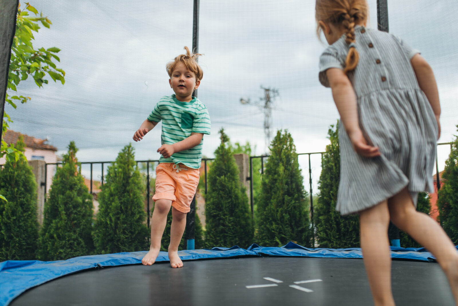 Kinderen springen op trampoline in achtertuin