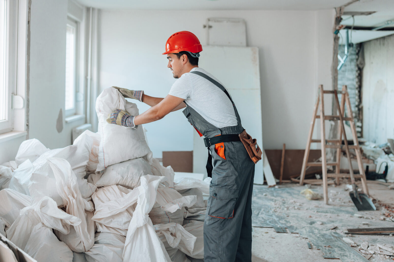 Man vult big bags met bouwafval tijdens renovatie in woning