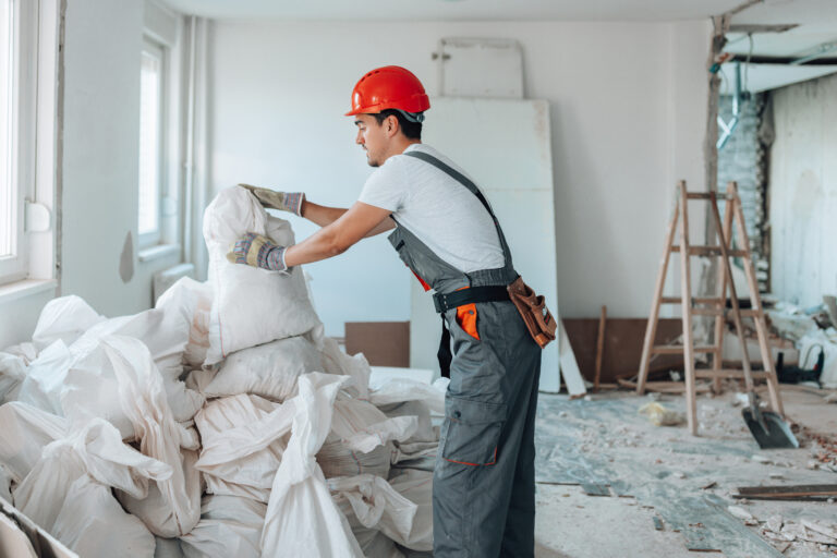 Man vult big bags met bouwafval tijdens renovatie in woning
