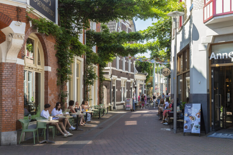 Straatbeeld in het centrum van Apeldoorn met winkels en terrassen
