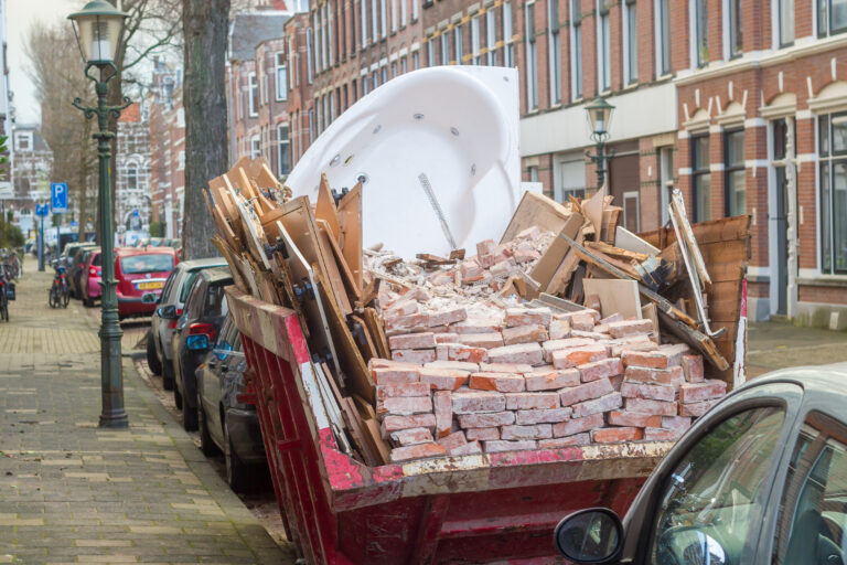Afvalcontainer in een smalle woonstraat zonder oprit