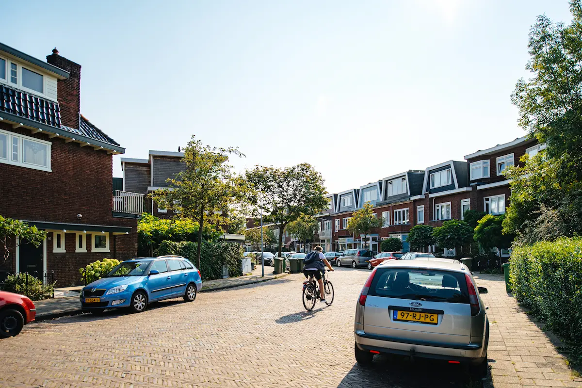 Rustige woonstraat in een Apeldoornse wijk met rijwoningen, geparkeerde auto’s en een fietser