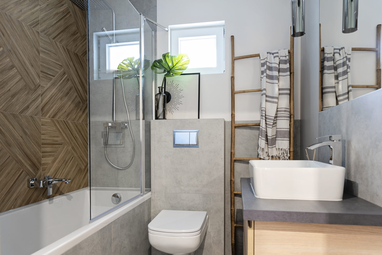 Kleine badkamer met badwand, toilet en badkamermeubel in lichte en warme materialen