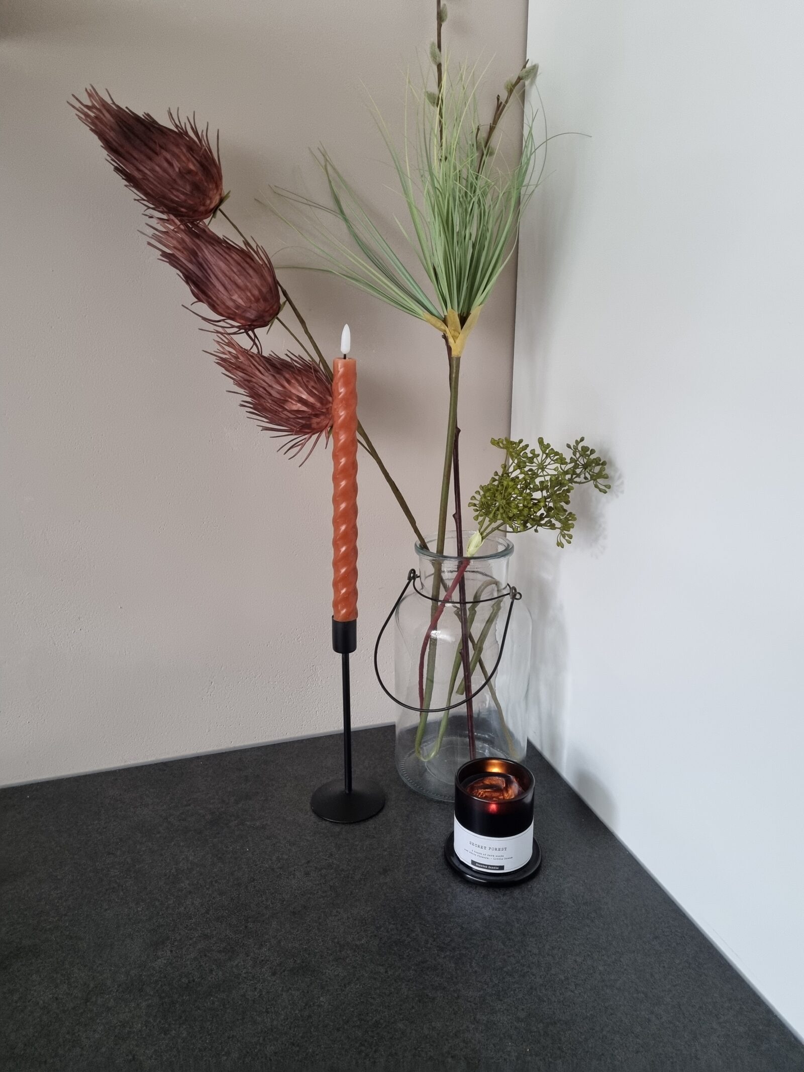 Kandelaars en kaarsen gecombineerd met woondecoratie op een dressoir