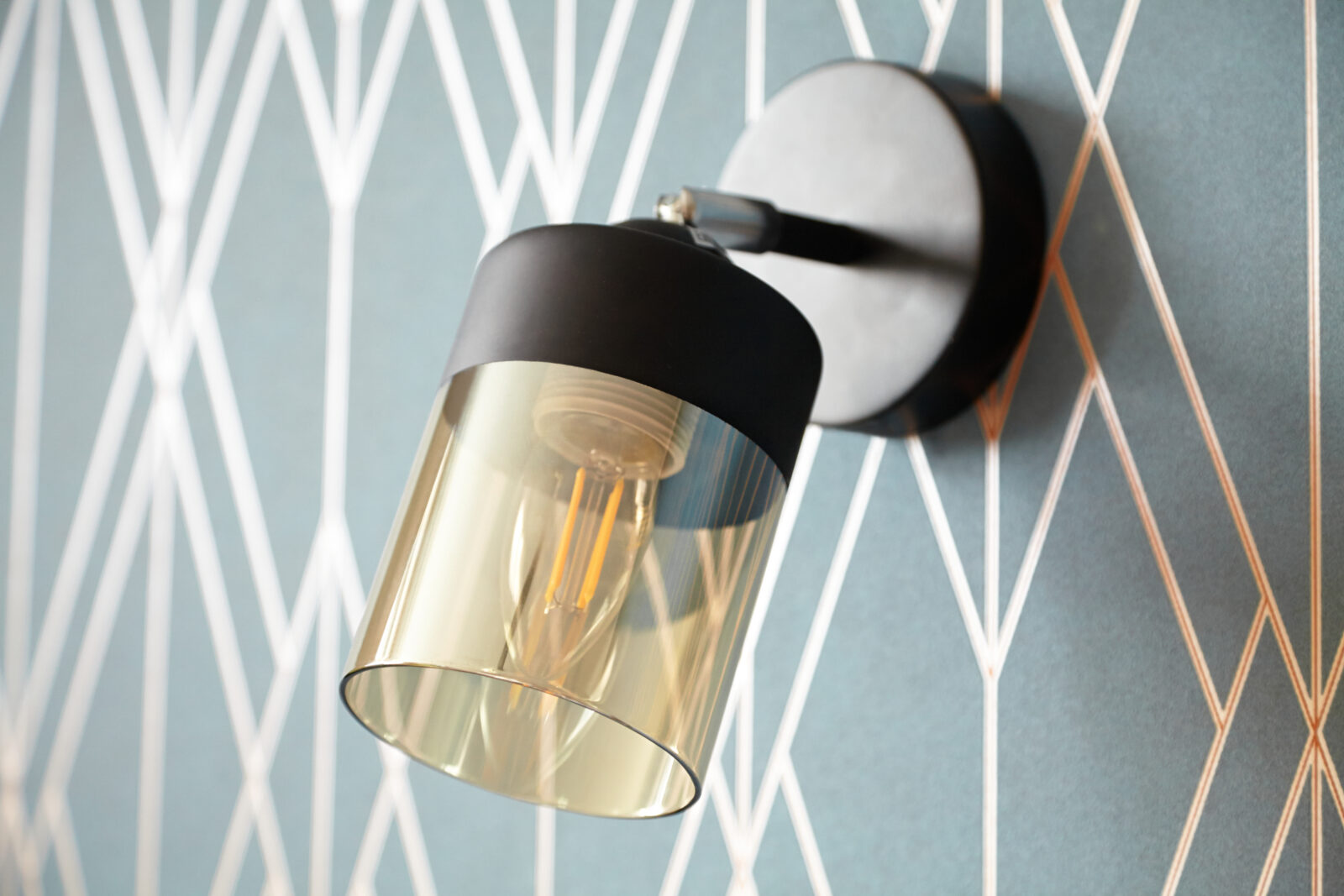 Zwarte wandlamp zonder zichtbaar snoer tegen een moderne wand