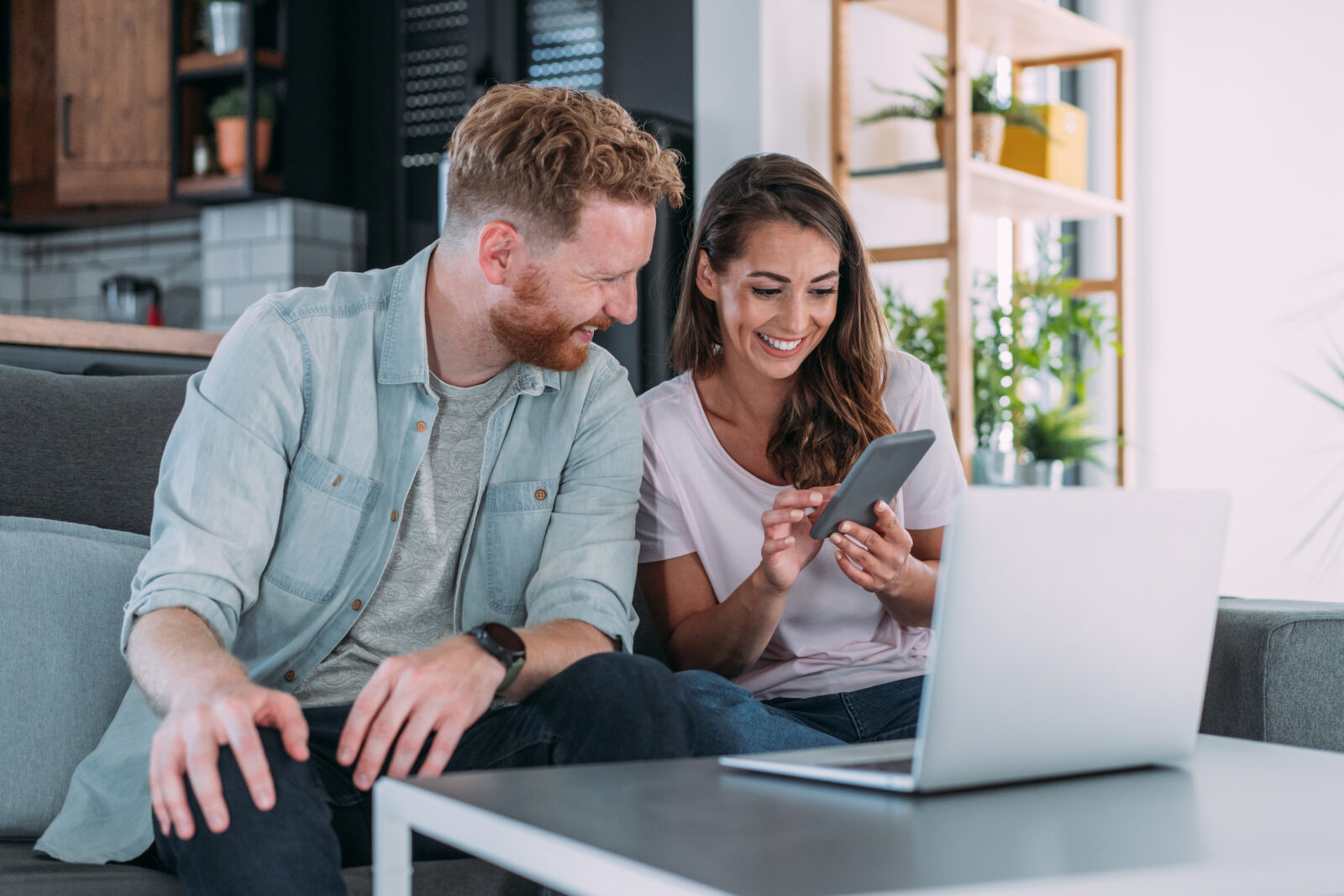 Stel bekijkt online woningaanbod op laptop en telefoon