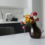 Kleurrijk boeket bloemen in een donkere vaas in een modern interieur