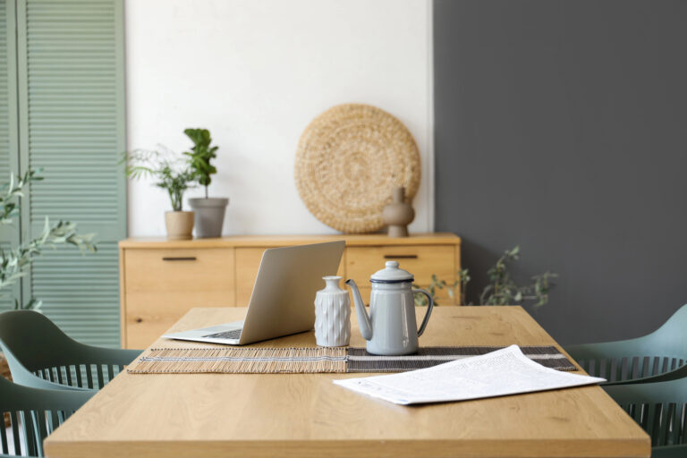 Laptop op een houten eettafel in een lichte woonkamer