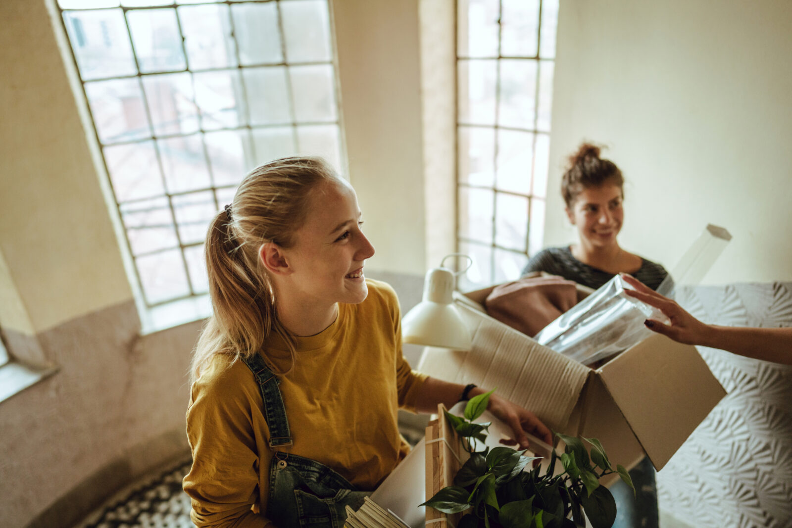 Twee mensen pakken verhuisdozen uit in een nieuwe woning