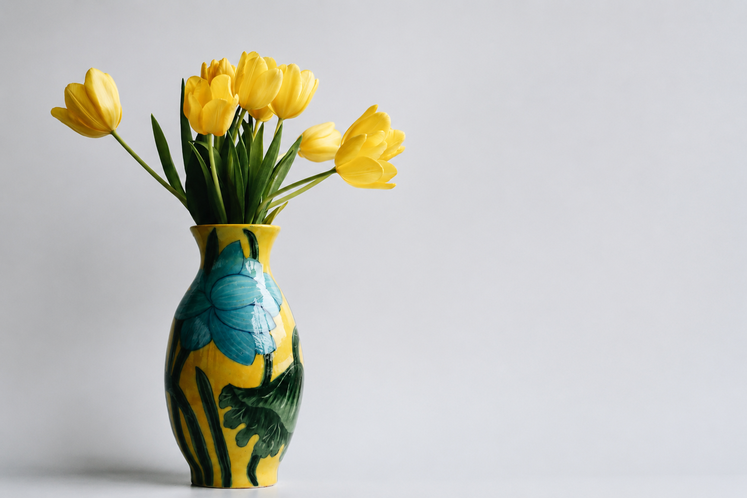 Gele tulpen in een kleurrijke keramieken statementvaas