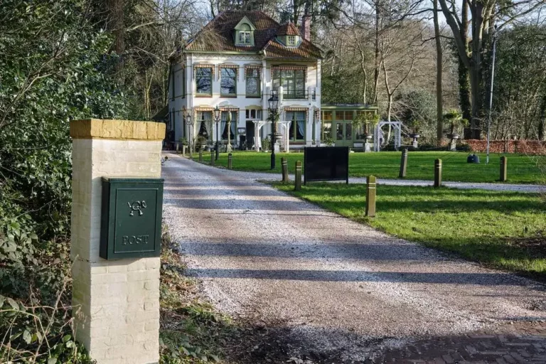 Vrijstaande brievenbus bij de oprit van een woning