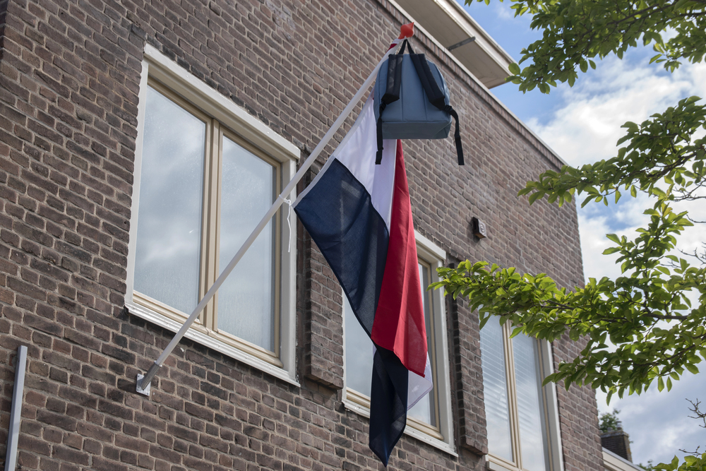 Geslaagd: de vlag uithangen met schooltas eraan